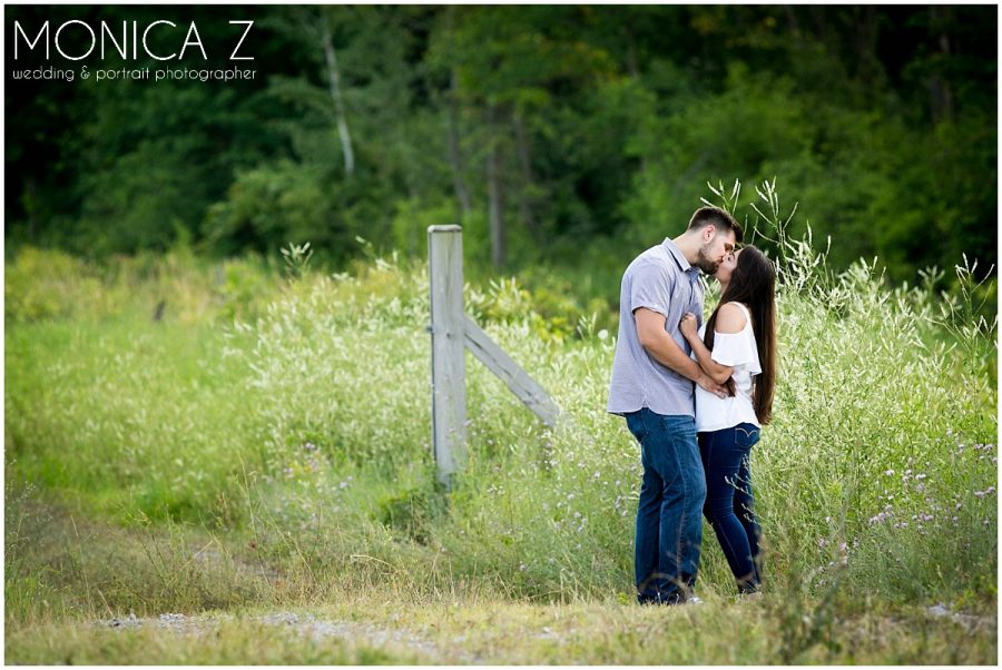 couple kissing in field engagement session. michigan city IN